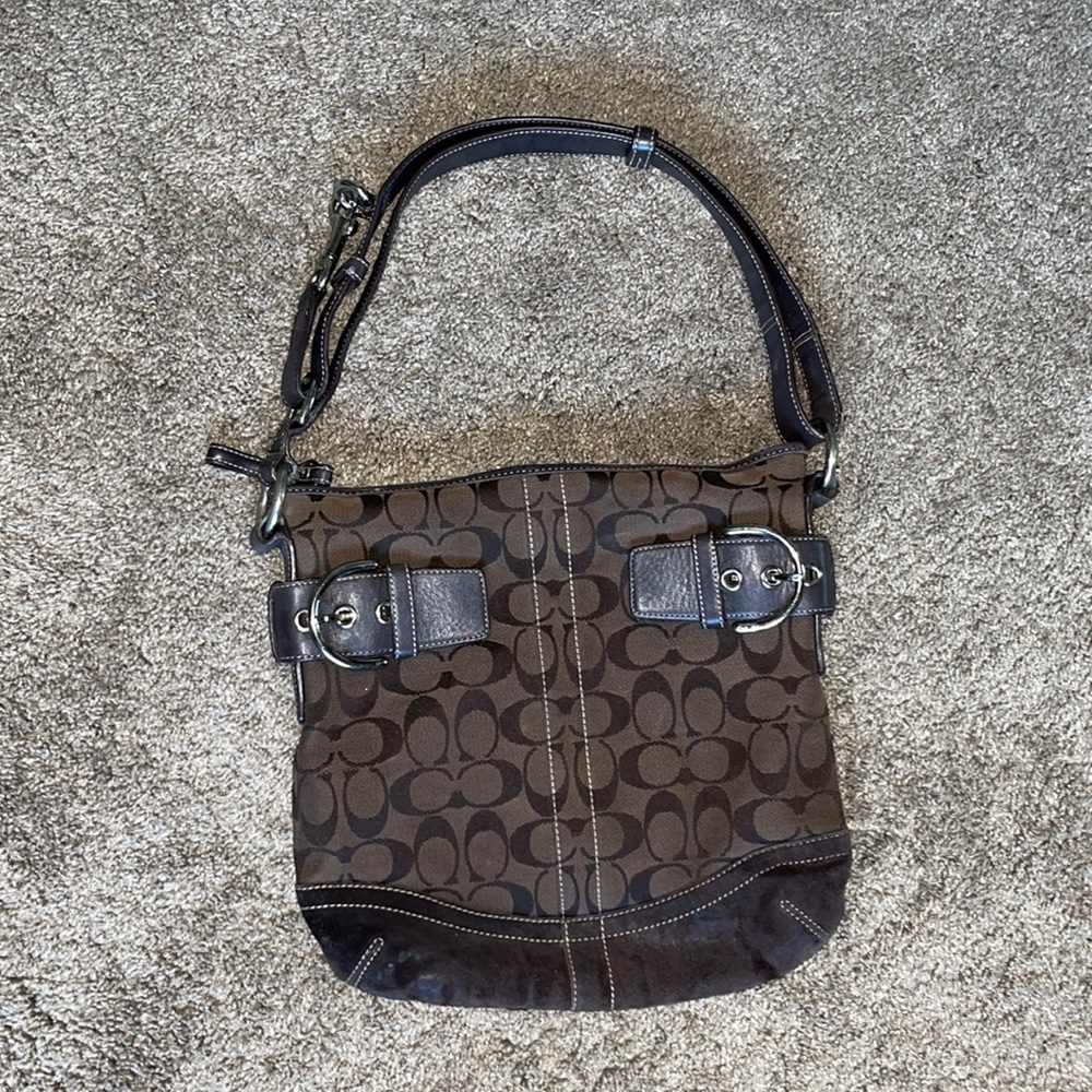 Previously loved brown coach signature slim soho hobo bag with buckle detail.